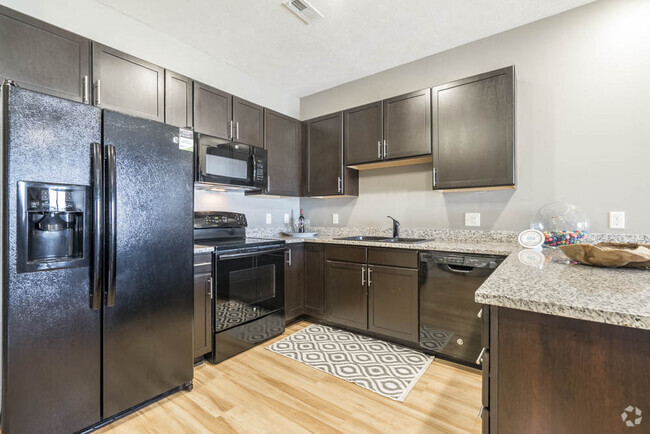 Our large kitchens feature granite countertops, modern hardware and ample storage. - The Flats at 84