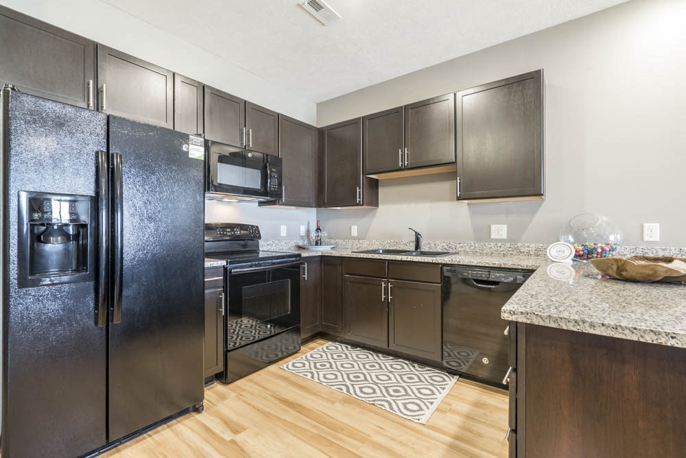 Our large kitchens feature granite countertops, modern hardware and ample storage. - The Flats at 84