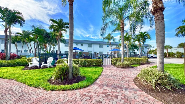 Enjoy a scenic stroll through lush tropical landscaping leading to the serene pool area. - Boca Winds