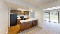 Located in Fort Wayne, Indiana, this two-story, 3-bedroom, 3-bathroom home offers a well-organized layout across two floors. The main level opens to a combined dining and living area with soft carpeting, neutral wall tones, and a pass-through window connecting to the kitchen — an efficient design that keeps the spaces feeling open and connected. The kitchen features warm wood cabinetry, white countertops, a tray ceiling with recessed lighting, hardwood flooring, and black appliances including a range, dishwasher, and refrigerator. A patio provides convenient outdoor access from the main living area. A half bathroom on the main level includes a wood-vanity with a white countertop and hardwood flooring. Upstairs, three carpeted bedrooms offer comfortable living spaces, including a generously sized primary bedroom. Secondary bedrooms feature vaulted ceilings and natural light from windows. Bedrooms are served by well-proportioned closets with louvered bifold doors. The upper-level bathrooms include a tiled tub-shower combination. With five closets total, ample hallways, and a utility room, this home provides practical storage and circulation throughout. The surrounding exterior features a green lawn with mature trees, lending a quiet, residential feel to the property.