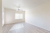 Located in Sun City West, Arizona, this single-story two-bedroom, one-bathroom home offers a bright and efficiently designed layout. The open living area is bathed in natural light streaming through large windows fitted with vertical blinds, and features light wood-style flooring and a ceiling fan that enhances the airy atmosphere. A sliding glass door provides convenient outdoor access directly from the living space.

The galley-style kitchen is well-appointed with warm wood cabinetry, granite-look countertops, a stainless steel sink, and a full suite of white appliances including a refrigerator, range, and dishwasher. Light wood flooring continues throughout the kitchen, maintaining a cohesive aesthetic.

Both bedrooms are carpeted and include ceiling fans and large windows that invite natural light. The primary bedroom offers generous proportions and connects to a walk-in closet with built-in shelving rods, providing ample storage. The second bedroom also benefits from a dedicated closet. A shared full bathroom features a shower-tub combination with wood-style vinyl flooring, completing the functional layout of this well-maintained home.