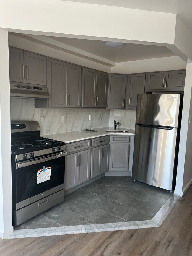 Open kitchen layout complete with countertops and rich wooden cabinetry - 1835 Atlantic Ave