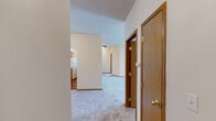 Located at 5015 South Regal Street in Spokane, Washington, this single-floor, 2-bedroom, 2-bathroom residence offers a comfortable and functional layout. The open-concept kitchen and living area serves as the heart of the home, featuring a wraparound breakfast bar, warm oak cabinetry, tile backsplash, and white appliances including a range, microwave, and refrigerator. An arched architectural detail adds character to the kitchen. The living room is bright and airy, with large windows and a glass door that invite natural light and outdoor views of the surrounding greenery.

Both bedrooms are carpeted and well-sized, with the spacious primary bedroom offering a generous closet with sliding wood-panel doors. Each room is served by baseboard heating. The two bathrooms are cleanly appointed — one features wood-look vinyl flooring, a tub-shower combo, and warm wood cabinetry, while the other includes a soaking tub with tile surround. A dedicated in-unit laundry space with a full-size washer and dryer adds everyday convenience. Neutral tones, warm wood accents, and plush carpeting throughout create a cohesive, inviting ambiance across the entire home.