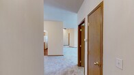 Located at 5015 South Regal Street in Spokane, Washington, this single-floor, 2-bedroom, 2-bathroom residence offers a comfortable and functional layout. The open-concept kitchen and living area serves as the heart of the home, featuring a wraparound breakfast bar, warm oak cabinetry, tile backsplash, and white appliances including a range, microwave, and refrigerator. An arched architectural detail adds character to the kitchen. The living room is bright and airy, with large windows and a glass door that invite natural light and outdoor views of the surrounding greenery.

Both bedrooms are carpeted and well-sized, with the spacious primary bedroom offering a generous closet with sliding wood-panel doors. Each room is served by baseboard heating. The two bathrooms are cleanly appointed — one features wood-look vinyl flooring, a tub-shower combo, and warm wood cabinetry, while the other includes a soaking tub with tile surround. A dedicated in-unit laundry space with a full-size washer and dryer adds everyday convenience. Neutral tones, warm wood accents, and plush carpeting throughout create a cohesive, inviting ambiance across the entire home.