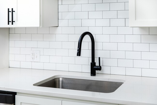 Kitchen with white quartz countertops and tile backsplash - Avalon South End