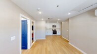 Located at 1060 Main St in South Windsor, CT, this modern one-bedroom, two-bathroom residence offers a thoughtfully designed single-floor layout with a clean, contemporary aesthetic throughout. Light-toned hardwood-style flooring flows seamlessly across the open living and kitchen areas, enhancing the bright and airy feel of the space.

The kitchen is a standout feature, outfitted with crisp white shaker cabinetry, white quartz countertops, a white tile backsplash, and a full suite of stainless steel appliances including a range, microwave, dishwasher, and refrigerator. Recessed lighting illuminates the space, while a bold navy blue entry door adds a striking design accent visible from the main living area.

The spacious primary bedroom offers a comfortable retreat with a large window that invites natural light and provides a connection to the outdoors. Three closets throughout the unit provide ample storage.

Both bathrooms are elegantly finished with large-format tile featuring a wood-look accent band. One bathroom includes a walk-in shower with a built-in shelf and grab bar, while the second features a full soaking tub with shower combo and a modern vanity. Together, they deliver a spa-like atmosphere with refined, contemporary finishes that complement the overall design of the home.
