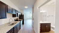 Located at 1023 Center View Rd in Sevierville, Tennessee, this single-floor unit offers a well-organized and functional layout designed to maximize its available space. Light hardwood-style flooring runs throughout the entire unit, providing a clean, cohesive aesthetic that ties each room together.

The open-concept kitchen and living area forms the heart of the unit. The kitchen is outfitted with rich dark espresso cabinetry, granite countertops, a stainless steel single-basin sink, and a full suite of stainless steel appliances including a refrigerator, electric range, and built-in microwave. A stacked washer and dryer unit is also conveniently tucked into the kitchen corridor. The adjacent living area is bright and airy, benefiting from a ceiling fan with integrated light fixture and a large window that allows ample natural light to fill the space.

The bathroom continues the consistent design language of the unit, featuring dark wood cabinetry with a granite-topped vanity, wood-look flooring, and clean white walls with brushed nickel towel bar hardware. A louvered closet door adds a classic touch to an additional room off the main living space, which also features a window with views of the surrounding neighborhood. The overall ambiance is clean, modern, and move-in ready.