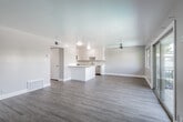 This well-appointed single-floor residence offers a clean, modern aesthetic throughout, characterized by a neutral color palette, crisp white trim, and abundant natural light. The open-concept layout seamlessly connects the living area to the kitchen, creating an airy and cohesive space ideal for everyday living and entertaining. Light wood-style flooring runs throughout the main living areas, adding warmth and continuity to the design.

The kitchen is thoughtfully equipped with white shaker-style cabinetry, stone-look countertops, a peninsula with additional workspace, and a full suite of stainless steel appliances, including a refrigerator, electric range, built-in microwave, and dishwasher. A ceiling fan in the living area provides year-round comfort, while large sliding glass doors open directly onto a private balcony overlooking a pool area, offering pleasant outdoor views and excellent cross-ventilation.

The bedroom is generously sized, finished with plush neutral carpeting, and features a wide window that fills the room with natural light. The full bathroom presents a clean and functional design with a white vanity, wood-style flooring, and a tub-shower combination with a frosted privacy window. The unit's overall layout, as seen in the dollhouse view, is well-organized and efficient, making excellent use of the available space.
