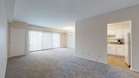 Located at 35 Severance Cir in Cleveland Heights, Ohio, this single-floor residence offers a well-organized and functional layout with a clean, neutral aesthetic throughout. The expansive living area is a standout feature, finished with plush wall-to-wall carpeting and a textured ceiling. Large vertical-blind-covered sliding doors allow generous natural light to fill the room, creating a bright and welcoming atmosphere. The open sightline connects the living area to the adjacent kitchen, which is outfitted with crisp white shaker-style cabinetry, granite-look countertops, a stainless steel sink, and wood-look flooring — providing a practical and attractive workspace. The bedroom is generously proportioned, also featuring soft carpeting and a set of sliding-door closets for ample storage, alongside an additional walk-in closet. A second room with carpeting and a vertical-blind window offers flexibility as a bedroom or additional living space. The bathroom is finished with wood-look flooring, a shower-tub combination, and a clean white vanity. Neutral tones and consistent finishes flow throughout, contributing to a calm and cohesive interior ambiance.