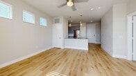Located in Leander, TX, this generously sized one-bedroom, one-bathroom unit offers a thoughtfully designed open-concept layout with modern finishes throughout. The combined kitchen and living area serves as the heart of the home, featuring light hardwood-style flooring, recessed and pendant lighting, and a ceiling fan. Large windows with plantation shutters fill the space with abundant natural light, while a glass-panel door opens to a private balcony with open sky views.

The kitchen is equipped with sleek gray cabinetry, granite countertops, a white subway tile backsplash, and a full suite of stainless steel appliances including a gas range, microwave, dishwasher, and refrigerator. A kitchen island provides additional counter space and casual seating.

The bedroom is carpeted for comfort and includes a ceiling fan, a bright window with blinds, and direct access to a spacious walk-in closet outfitted with multiple hanging rods and shelving. The full bathroom features gray vanity cabinetry, granite countertops, a large framed mirror with overhead lighting, upper storage cabinets, and marble-style tile accenting the walls, creating a clean and polished aesthetic throughout.