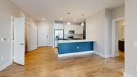 This well-appointed single-floor residence offers a thoughtfully designed layout that balances modern style with everyday functionality. The open-concept living and kitchen area serves as the heart of the home, featuring warm wood-look flooring, recessed lighting, and a striking kitchen island with a bold navy-blue base and clean white countertop. The kitchen is equipped with stainless steel appliances, white shaker-style cabinetry, a decorative tile backsplash, and pendant lighting that adds a contemporary touch. A dedicated laundry area with a full-size washer and dryer is conveniently accessible just off the kitchen. The bedrooms are finished with plush wall-to-wall carpet and neutral toned walls, with windows that invite natural light and offer views of lush greenery. Ceiling fans enhance comfort in the primary bedroom. The bathrooms are elegantly appointed with navy-blue vanity cabinetry, granite countertops, and large mirrors, while the primary bath features a dual-sink vanity, a glass-enclosed shower, and open shelving. A spacious walk-in closet with wire shelving provides ample storage. Clean white trim and panel doors throughout complete the cohesive, modern aesthetic of this well-designed home.