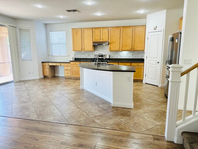 Cocina abierta con isla de granito y electrodomésticos de acero inoxidable. - 1177 W Laredo Ave