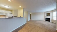 Located in Avon Lake, Ohio, this single-floor residence offers a practical and comfortable layout designed for everyday living. The open-concept living area is generously proportioned, featuring warm neutral-toned carpet, a textured ceiling, and a half-wall breakfast bar that visually connects the space to the kitchen. Recessed lighting adds a subtle warmth to the living area, which flows openly toward additional rooms via a connecting hallway.

The kitchen is well-appointed with an abundance of white raised-panel cabinetry extending to the upper walls, providing ample storage. Light-toned laminate countertops, a stainless steel sink, white appliances including a gas range and dishwasher, and tile flooring complete the functional space.

The bedrooms are carpeted and finished in soft neutral tones, each featuring windows that allow natural light to filter in. One bedroom includes direct access to a private bathroom, while a second full bathroom serves the remaining rooms. Both bathrooms feature tile flooring, a vanity with white cabinetry, a large mirror, and a tub-shower combination, maintaining a consistent, clean aesthetic throughout the home.