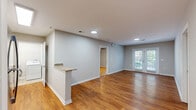 Located on Wilshire Boulevard in Wilmington, NC, this well-appointed 2-bedroom, 2-bathroom residence offers a thoughtfully designed single-floor layout with a clean, modern aesthetic throughout. Warm wood-look flooring runs continuously through the main living areas and bedrooms, creating a cohesive and inviting atmosphere.

The open-concept kitchen and living area serves as the heart of the home. The kitchen is outfitted with white shaker-style cabinetry, granite countertops, a full suite of stainless steel appliances — including a refrigerator, range, microwave, and dishwasher — and a peninsula breakfast bar that provides additional prep space and casual seating. The adjacent living room is bright and airy, enhanced by recessed lighting and a set of French doors that fill the space with natural light and open to an outdoor area.

Both bedrooms are comfortably sized, featuring the same warm flooring, neutral gray walls, and ample natural light. The primary bedroom is generously proportioned and includes a ceiling fan. A dedicated closet provides practical storage.

The two bathrooms are identically finished with white cabinetry, granite-topped vanities, tub/shower combinations, brushed nickel fixtures, and neutral tile flooring — offering a consistent, polished look throughout the home.