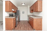 Located at 1920 Chene St in Detroit, Michigan, this single-floor residential unit offers a practical and well-organized layout designed for comfortable everyday living. The open-concept living area is generously sized, finished with neutral-toned carpet, and anchored by a large sliding glass door with vertical blinds that fills the space with natural light and provides access to the outdoors. A half-wall partition separates the living area from the kitchen, which features warm wood-toned cabinetry, light countertops, and a stainless steel refrigerator. The kitchen transitions to hardwood-style flooring, offering a clean contrast to the carpeted living zones. The bedrooms are bright and spacious, each featuring plush carpeting, blinds-fitted windows that bring in natural light, and neutral walls. One bedroom includes a walk-in closet, providing notable storage capacity. The bathroom is finished with hardwood-style flooring, a vanity with cabinetry, and a wall-mounted mirror. Throughout the unit, the design emphasizes functionality with a clean, understated aesthetic, neutral color palette, and consistent finishes that create a cohesive and livable environment.