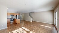 Located at 1 Abby Ln in Ballston Lake, NY, this two-story home offers a functional and comfortable layout across two floors. The main level features a bright, open-concept living room and kitchen combination with warm hardwood-style flooring that draws in generous natural light. The kitchen is well-equipped with honey-toned wood cabinetry, dark granite countertops, a center island with pendant lighting, and a full suite of stainless steel appliances including a refrigerator, range, microwave, and dishwasher. A staircase connects the main level to the upper floor, which houses the majority of the bedrooms, including a spacious primary bedroom with plush carpeting and ample natural light from large windows. A walk-in closet with wire shelving provides generous storage. The upper floor also features additional bedrooms with carpet flooring and well-lit interiors. Three bathrooms serve the home, including a pedestal-sink powder room on the main level. The home also includes a utility room, multiple hallways for easy circulation, and an attached garage with an automatic opener. Neutral tones throughout create a clean, move-in ready atmosphere.