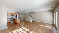 Located at 1 Abby Ln in Ballston Lake, NY, this two-story home offers a functional and comfortable layout across two floors. The main level features a bright, open-concept living room and kitchen combination with warm hardwood-style flooring that draws in generous natural light. The kitchen is well-equipped with honey-toned wood cabinetry, dark granite countertops, a center island with pendant lighting, and a full suite of stainless steel appliances including a refrigerator, range, microwave, and dishwasher. A staircase connects the main level to the upper floor, which houses the majority of the bedrooms, including a spacious primary bedroom with plush carpeting and ample natural light from large windows. A walk-in closet with wire shelving provides generous storage. The upper floor also features additional bedrooms with carpet flooring and well-lit interiors. Three bathrooms serve the home, including a pedestal-sink powder room on the main level. The home also includes a utility room, multiple hallways for easy circulation, and an attached garage with an automatic opener. Neutral tones throughout create a clean, move-in ready atmosphere.