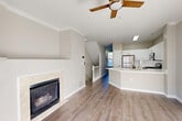 Located at 508 Pride Avenue in Herndon, Virginia, this three-story townhouse offers a well-organized layout across three distinct levels. The ground floor houses a garage with an automatic opener, providing convenient off-street parking and additional storage space. Entry to the home is welcomed by a clean foyer with light wood-style flooring and carpeted stairs leading to the main living areas. The main floor serves as the heart of the home, featuring an open-concept living and dining area centered around a tiled fireplace and ceiling fan. Sliding glass doors open to a private balcony, allowing ample natural light to fill the space. The kitchen is equipped with white shaker cabinets, a large peninsula with quartz countertops, stainless steel appliances including a gas range, microwave, and refrigerator, as well as a pantry for extra storage. The upper floor hosts three bedrooms, each with hardwood-style flooring, natural light from windows, and closet space. The primary bedroom includes a dedicated closet with built-in shelving. A full bathroom on this level features a tub/shower combination with tile surround. Laundry and utility areas round out the functional offerings of this efficiently designed home.
