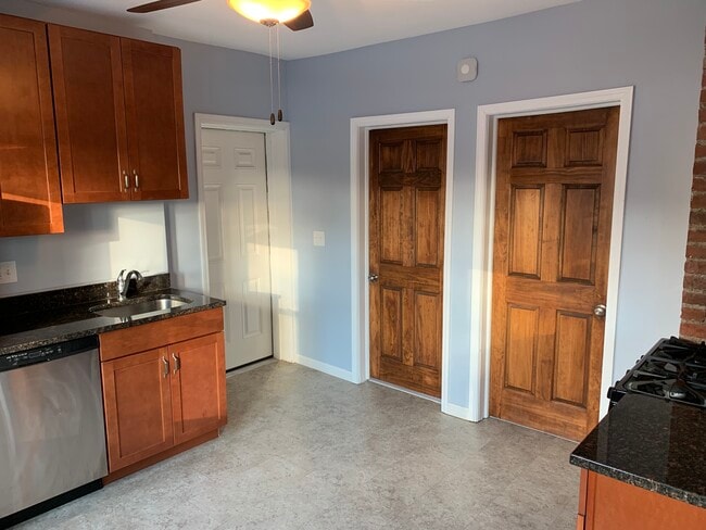 Kitchen - Apartment entrance, bathroom door, bedroom 1 door. All wood doors are stained with a dark brown finish. - 3817 Lorain Avenue