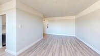 Located at 121 Minerva Ave in the Cliffcrest neighbourhood of Toronto, this well-appointed two-bedroom, one-bathroom unit offers a clean, modern aesthetic throughout. Light wood laminate flooring extends across the entire space, creating a warm and cohesive feel from room to room.

The galley-style kitchen is thoughtfully designed with dual-tone cabinetry — white uppers paired with grey lowers — complemented by crisp white quartz countertops and a subway tile backsplash. Stainless steel appliances, including a refrigerator and electric range, complete the functional layout. A hallway connects the kitchen to the rest of the unit, providing a natural flow through the space.

The primary bedroom is a comfortable size, featuring neutral walls, a closet, and access to an adjacent room or hallway. The second bedroom benefits from a large window that invites generous natural light and overlooks a quiet outdoor scene, with a radiator providing consistent warmth. Both bedrooms feature clean white trim and soft neutral tones throughout.

The bathroom is finished with white tile surround in the tub and shower area, a quartz vanity countertop, and bright, reflective surfaces that enhance the sense of cleanliness and space. A private balcony extends the living area outdoors, offering additional versatility. The unit is rounded out by a dedicated hallway entry, providing a practical transition into the home.