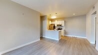 This 2-bedroom, 2-bathroom residence in Chino Hills, CA offers a well-organized single-floor layout designed for comfortable everyday living. The open-concept living area is finished with light wood-style flooring and neutral-toned walls, creating a bright and airy atmosphere. A sliding glass door leads to a private balcony, allowing natural light to fill the space while providing pleasant outdoor views of surrounding greenery.

The kitchen is positioned adjacent to the living area and features a peninsula with pendant lighting, white shaker-style cabinetry, a marble-look tile backsplash, and a full suite of stainless steel appliances including a refrigerator, range, and microwave. The layout promotes easy interaction between the kitchen and living spaces.

The primary bedroom offers a comfortable footprint with plush carpeting, a large bay-style window with a built-in bench seat, and ample natural light. The second bedroom also features carpet flooring and a window with vertical blinds. Both bathrooms are appointed with white vanity cabinetry and well-lit mirrors. A hallway and dedicated closet provide practical storage throughout. The overall design emphasizes clean lines, neutral finishes, and functional flow.