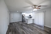 Located at Rookery Bay Drive in Naples, Florida, this 1-bedroom, 2-bathroom residence offers a thoughtfully designed single-floor layout with modern finishes throughout. The open-concept living and kitchen area is anchored by light wood-look plank flooring, recessed lighting, and a ceiling fan, creating a bright and airy atmosphere. The kitchen stands out with crisp white shaker cabinetry, a white quartz peninsula countertop, a subway tile backsplash, and a full suite of stainless steel appliances. Sliding glass doors and multiple windows allow natural light to fill the living area. The spacious primary bedroom features its own ceiling fan, a large window with natural light, and direct access to both a dedicated closet and the primary bathroom. The primary bath is elegantly appointed with a dual-sink white vanity, brushed nickel hardware, and a walk-in shower adorned with large-format marble-look porcelain wall tiles, hexagonal mosaic floor tiles, and a built-in niche — delivering a spa-like experience. A hallway connects the living spaces with the second bathroom, closet, and bedroom, contributing to a functional and efficient floor plan. The clean, neutral palette and quality finishes throughout lend the residence a polished, move-in-ready character.