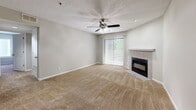 Located at 3250 Mercer University Dr in Chamblee, GA, this two-bedroom, single-floor residence offers a practical and comfortable layout finished with neutral tones throughout. The open living room serves as the heart of the home, featuring a tile-surround fireplace, a ceiling fan with light fixture, plush carpeting, and a sliding glass door that invites natural light and outdoor views. Adjacent to the living area, the galley-style kitchen is well-appointed with white cabinetry, dark countertops, wood-look vinyl flooring, and black appliances including a range, microwave, and refrigerator. The spacious primary bedroom features carpet flooring, a window with blinds for natural light, and direct access to a private bathroom and a walk-in closet. The second bedroom is similarly carpeted and includes a window overlooking the exterior greenery, offering a bright and comfortable space. A hallway connects the bedrooms and provides access to an additional closet for extra storage. Throughout the residence, soft warm-gray walls, textured ceilings, and white trim create a cohesive and clean aesthetic that lends itself well to a variety of interior styles.