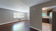 Located at 2 Lakeview Dr in Peekskill, NY, this single-floor residence offers a well-organized layout with a clean, contemporary aesthetic throughout. Rich, dark hardwood flooring flows seamlessly across the living areas and bedrooms, providing a warm and polished foundation for the entire space.

The open living area is bright and airy, benefiting from multiple windows that frame views of surrounding greenery and allow ample natural light to fill the room. A ceiling fan adds both function and a finishing touch to the space. A wall-mounted air conditioning unit and baseboard heating ensure year-round comfort.

The kitchen is thoughtfully updated, featuring dark espresso cabinetry with sleek bar-pull hardware, white quartz countertops, a marble-style tile backsplash, stainless steel appliances, and light tile flooring. A window above the sink overlooks lush outdoor foliage, adding a pleasant natural element to the cooking space.

The bedrooms continue the hardwood flooring and neutral gray wall palette, with sliding closet doors providing practical built-in storage with hanging rods. The bathroom is finished with large-format light gray wall tiles surrounding a full soaking tub, brushed nickel fixtures, and a window that introduces natural ventilation and light. The overall ambiance of this residence is clean, modern, and move-in ready.