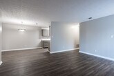 Located at 540 Belle Dr in Fayetteville, GA, this single-story residence offers a cohesive, move-in-ready interior defined by warm hardwood-style flooring that runs throughout the home and a consistent neutral color palette of soft grays and warm beiges. The open living and dining areas flow naturally into one another, with a pendant light fixture marking the dining space and a textured ceiling adding subtle architectural character. A sliding glass door fitted with vertical blinds allows natural light to fill the living area while providing access to the outdoors.

The kitchen is laid out in a galley configuration, featuring taupe cabinetry, light quartz-style countertops, a tile backsplash, a stainless steel sink, and black appliances including a refrigerator and range. A door from the kitchen leads to an additional utility or storage area.

The bedrooms are generously proportioned, each equipped with ceiling fans and walk-in or reach-in closets with built-in shelving. Natural light enters through slatted blinds, enhancing the bright, airy feel of each room.

The bathroom is well-appointed with a soaking tub and shower combination, a taupe vanity with a light countertop, a framed mirror with built-in shelving, and hardwood-style flooring that ties the space together cohesively.