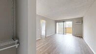 Located at 13729 Via Del Palma Ave in Whittier, CA, this one-bedroom, one-bathroom unit offers a well-organized single-floor layout encompassing a living room, kitchen, bedroom, bathroom, entrance, hallway, and closet. The living room is a bright, open space finished with light wood-style flooring, neutral gray walls, and a textured ceiling. A sliding glass door fitted with vertical blinds opens to a private balcony, allowing natural light to pour in and providing outdoor views of surrounding greenery. A wall-mounted air conditioning unit ensures year-round comfort. The galley-style kitchen features white cabinetry, laminate countertops, a double-basin sink, white appliances including a range and refrigerator, and track lighting overhead. A window with vertical blinds and a frosted glass accent panel bring additional light into the space. The bedroom offers a comfortable footprint with plush carpeting, a large window, a textured ceiling, and access to a dedicated closet. The bathroom is equipped with a shower-tub combination, a white vanity with storage, and wood-style flooring. The entrance hallway also features wood-style flooring, providing a cohesive transition throughout the unit. Overall, the space presents a clean, neutral palette ideal for a variety of living arrangements.