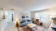 Located at 5300 Catalina Circle Dr in Hilliard, Ohio, this well-appointed 2-bedroom, 1-bathroom single-floor residence offers a comfortable and functional layout designed for everyday living. The bright living room serves as the heart of the home, featuring light wood-style flooring, a textured ceiling, a bold navy accent wall, and large windows dressed with sheer curtains that invite generous natural light and outdoor views. The open-concept kitchen connects seamlessly to the dining area, showcasing granite countertops, white cabinetry, recessed lighting, a peninsula breakfast bar, and black appliances — all accented by a modern sputnik chandelier overhead. The primary bedroom is a spacious, carpet-floored retreat with a large window, ample room for furnishings, and access to a dedicated walk-in closet with built-in shelving and hanging space. The second bedroom also features carpet flooring and a clean, neutral palette. The full bathroom is neatly appointed with a single-sink vanity, tub-shower combination, and wood-look flooring. A dedicated laundry area houses a full-size side-by-side washer and dryer. Two hallways provide smooth connectivity throughout the unit, rounding out a thoughtfully organized floor plan.