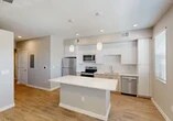 Located at 3065 Champion Ring Rd in Fort Myers, FL, this efficiently designed one-bedroom, one-bathroom residence offers a thoughtfully laid-out single-floor plan with modern finishes throughout. The open-concept kitchen serves as the centerpiece of the living space, showcasing flat-front white upper cabinetry, warm wood-toned lower cabinets, and a full suite of stainless steel appliances including a refrigerator, range, microwave, and dishwasher. A white quartz-topped central island provides additional prep space and casual seating, while dual pendant lights add a contemporary touch overhead. A classic subway tile backsplash completes the clean, modern aesthetic. Light wood-look flooring runs seamlessly throughout the space, lending warmth and visual continuity. A hallway connects the kitchen and living area to the private bedroom, a calm and neutral room with soft gray walls and ample natural light. The dedicated closet offers convenient storage. The bathroom features full-height large-format tile surrounding a soaking tub and shower combo, accented by brushed nickel hardware and a built-in niche — a refined and functional design. Recessed lighting throughout ensures a bright, welcoming ambiance across every room.