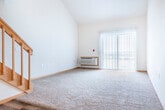 Located at 1118 N Pleasant View Rd in Madison, Wisconsin, this two-story home offers a well-organized layout spread across two floors. The main level features a combination of rich hardwood-style flooring and plush carpeting, creating a warm and inviting atmosphere. A carpeted living area anchors the main floor, complemented by a staircase with classic wood railings that leads to the upper level. Natural light filters in through vertical-blind-covered windows, brightening the open spaces throughout.

The upper floor houses the generously sized primary bedroom, which features soft carpeting, high ceilings, and a large window with a transom that floods the room with natural light. Two closets provide ample storage, including a walk-in closet equipped with multi-tiered wood shelving and hanging rods. Both bathrooms are finished with hardwood-style flooring and white cabinetry. The first bathroom includes a single-sink vanity with a large mirror and a tub/shower combo, while the second bathroom features a glass-enclosed shower stall alongside a separate vanity and toilet. Warm wood trim accents throughout the home tie the design together, giving the space a cohesive and comfortable aesthetic.