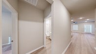 Located at 27035 Beacon Glen Drive in Katy, TX, this single-story home offers a thoughtfully designed layout across a comfortable footprint. The open-concept kitchen serves as a central highlight, featuring white shaker cabinetry extending to the ceiling, granite countertops, a subway tile backsplash, stainless steel appliances including a gas range and French door refrigerator, and a center island with an undermount sink—ideal for both cooking and casual dining. Light wood-look flooring flows through the main living areas, complementing the bright, neutral color palette throughout.

The living room is well-proportioned, with multiple windows fitted with blinds that allow natural light while maintaining privacy, and a ceiling fan overhead. Both bedrooms are carpeted and similarly equipped with ceiling fans and natural light from framed windows. The generously sized primary bedroom connects to a bathroom with a wide vanity, white cabinetry, and a tiled shower. Walk-in closets with built-in shelving and hanging rods provide ample storage in both bedrooms. A dedicated laundry room accommodates a full-size washer and dryer. Clean hallways with light flooring connect the home's spaces efficiently, creating a cohesive and functional layout.
