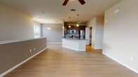 This single-floor residence offers a thoughtfully designed open-concept layout that seamlessly connects the living, dining, and kitchen areas. Wide-plank hardwood-style flooring flows throughout the main living spaces, complemented by neutral wall tones that create a clean, contemporary ambiance. The spacious living area is brightened by multiple windows with natural light streaming in, and a ceiling fan adds comfort overhead. French doors lead to an outdoor area, further enhancing the sense of openness.

The kitchen is a standout feature, boasting dark espresso cabinetry, granite countertops, and a full suite of stainless steel appliances including a refrigerator with ice maker, electric range, microwave, and dishwasher. A central island with pendant lighting provides both prep space and a casual dining option. A stacked washer and dryer unit is conveniently housed nearby.

The bedrooms are carpeted for warmth and comfort, each featuring ceiling fans and ample closet space. Natural light enters through sizable windows with blinds. The bathrooms are well-appointed with dark wood vanities, granite countertops, and a tiled tub-shower combination. Grab bars and generous mirror space add functionality. The entry staircase with metal railings provides a welcoming arrival point to this well-rounded, move-in-ready home.