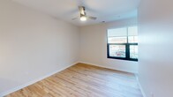 This compact yet well-designed 470 square foot apartment in Cedar Rapids, Iowa, maximizes space efficiency without compromising on style. The single-floor layout includes a modern kitchen, a full bathroom, and a versatile living area. The kitchen is a highlight, boasting sleek white cabinetry, stainless steel appliances, and a practical island with a sink, creating an open and functional cooking space. Pendant lighting adds a touch of elegance, while the light-colored quartz countertops enhance the bright, airy feel. The bathroom features a full-sized bathtub with a curved shower rod, ensuring comfort in the compact space. Throughout the apartment, beautiful hardwood floors add warmth and character. The living area is illuminated by natural light from a large window and is equipped with a modern ceiling fan. Recessed lighting throughout contributes to the contemporary ambiance. Despite its modest size, the apartment's thoughtful design and high-quality finishes make it feel spacious and inviting.