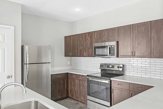 Las cocinas renovadas incluyen electrodomésticos de acero inoxidable ENERGY STAR®, encimeras de cuarzo y un elegante protector contra salpicaduras de azulejos. - Alister Sunset Valley