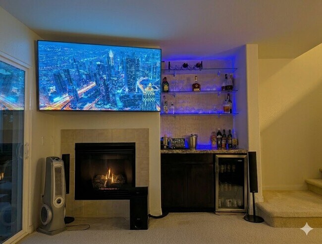 Televisor en la sala de estar, chimenea, bar, mininevera y centro de entretenimiento oculto. - 3542 Shoreline Bluff Lane