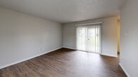 Located in Auburn, WA, this single-floor unit offers three bedrooms, one bathroom, and a practical, well-organized layout. The living room is bright and open, featuring wood-style flooring, a ceiling fan, and a large sliding glass door with vertical blinds that invites natural light and outdoor views. The galley-style kitchen is efficiently designed with dark espresso cabinetry lining both walls, light stone-look countertops, a stainless steel refrigerator, an electric range, a dishwasher, and a single-basin sink. A window at the end of the kitchen adds natural light and ventilation. The three bedrooms are carpeted and feature textured ceilings, windows with blinds for natural light, and sliding-door closets with built-in rods and shelving. The primary bedroom offers a comfortable footprint with room to furnish generously. The shared bathroom includes a dark-cabinet vanity with a wide mirror, light countertop, wood-style flooring, a soaking tub, and an accessibility grab bar. A hallway connects the main living spaces to the bedrooms and bathroom. Throughout the unit, textured ceilings and baseboard heating are consistent design elements, contributing to a functional and cohesive living environment.