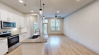 Located at 800 West Pasadena Boulevard in Deer Park, TX, this well-appointed two-bedroom, two-bathroom residence offers a thoughtfully designed single-level layout with modern finishes throughout. Light wood flooring extends across the main living areas, creating a warm, cohesive aesthetic. The open-concept living, dining, and kitchen area forms the heart of the home, bathed in natural light from multiple large windows dressed with blinds. A ceiling fan adds comfort to the living space, while stylish pendant lights illuminate the kitchen island. The kitchen is equipped with white shaker cabinetry, quartz countertops, stainless steel appliances including a refrigerator, range, and microwave, and a deep undermount sink with a gold-toned faucet. The primary bedroom is generously sized, featuring a ceiling fan, wide windows with outdoor views, and direct access to a spacious walk-in closet with built-in wire shelving. The en-suite primary bathroom offers a dual-sink vanity with quartz countertops, a glass-enclosed shower, and tile flooring. The second bedroom is bright and well-proportioned, also enjoying outdoor views. Additional highlights include a dedicated laundry room with a full-size washer and dryer, ample closet storage throughout, and a private balcony.