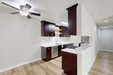 Located at 6740 Hayvenhurst Ave in Los Angeles, CA, this 2-bedroom, 2-bathroom single-floor unit offers a well-designed layout that makes efficient use of its space. Light hardwood-style flooring runs throughout, creating a cohesive and clean aesthetic across every room.

The kitchen is a standout feature, showcasing rich dark espresso cabinetry with brushed nickel hardware, crisp white countertops, a stainless steel dishwasher, gas range, and refrigerator. A skylight overhead floods the space with natural light, while a peninsula counter provides additional prep space and a casual dining option. A ceiling fan in the adjoining area aids ventilation and comfort.

The living room is bright and airy, benefiting from large sliding windows that invite generous natural light and feature a wall-mounted air conditioning unit. Textured ceilings add a classic touch throughout the common areas.

The primary bedroom is a comfortable retreat, offering mirrored sliding closet doors that enhance the sense of space, along with a window for natural light. The second bedroom also features hardwood-style floors and a wall heater unit.

Both bathrooms are finished with matching dark vanity cabinetry, white countertops, framed mirrors, and contemporary lighting fixtures, maintaining a consistent design language throughout the unit.