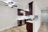 Located at 6740 Hayvenhurst Ave in Los Angeles, CA, this 2-bedroom, 2-bathroom single-floor unit offers a well-designed layout that makes efficient use of its space. Light hardwood-style flooring runs throughout, creating a cohesive and clean aesthetic across every room.

The kitchen is a standout feature, showcasing rich dark espresso cabinetry with brushed nickel hardware, crisp white countertops, a stainless steel dishwasher, gas range, and refrigerator. A skylight overhead floods the space with natural light, while a peninsula counter provides additional prep space and a casual dining option. A ceiling fan in the adjoining area aids ventilation and comfort.

The living room is bright and airy, benefiting from large sliding windows that invite generous natural light and feature a wall-mounted air conditioning unit. Textured ceilings add a classic touch throughout the common areas.

The primary bedroom is a comfortable retreat, offering mirrored sliding closet doors that enhance the sense of space, along with a window for natural light. The second bedroom also features hardwood-style floors and a wall heater unit.

Both bathrooms are finished with matching dark vanity cabinetry, white countertops, framed mirrors, and contemporary lighting fixtures, maintaining a consistent design language throughout the unit.