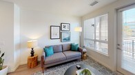 This thoughtfully designed single-floor residence showcases a cohesive modern aesthetic with clean lines and contemporary finishes throughout. The kitchen is a standout feature, outfitted with dark wood-grain cabinetry, light quartz countertops, a classic white subway tile backsplash, and a full suite of stainless steel appliances, including a range, over-the-range microwave, refrigerator, and dishwasher. Light wood-style flooring runs through the kitchen and connects seamlessly to the rest of the common areas.

The living room is bright and welcoming, featuring large windows fitted with horizontal blinds that fill the space with natural light. A glass-panel door provides direct access to an outdoor area, enhancing the sense of openness. Wood-style flooring continues through this space, complementing the room's warm, modern character.

Two carpeted bedrooms offer comfortable retreats, each equipped with a ceiling fan and ample natural light from generously sized windows. The bedrooms feature neutral tones and clean white walls that create a calm, restful ambiance.

The bathroom maintains the same contemporary design language, with a dark-wood vanity, white quartz countertop, a large wall mirror, wood-style flooring, and a tiled shower-tub combination. The overall design of this residence is unified, modern, and functional.