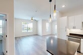 Located at 1000 Jasper Ln in Saint Peters, MO, this well-appointed single-story home offers 2 bedrooms and 2 bathrooms across a thoughtfully designed floor plan. The open-concept kitchen and living area serves as the heart of the home, featuring white shaker cabinetry, dark countertops, a subway tile backsplash, and stainless steel appliances including a refrigerator, range, and built-in microwave. A kitchen island with pendant lighting anchors the space, while light hardwood-style flooring and recessed lighting create a bright, modern ambiance. The living area is bathed in natural light from multiple windows and provides access to an outdoor area through glass French doors. Both bedrooms are carpeted and equipped with ceiling fans, with the generously sized primary bedroom featuring a walk-in closet with wire shelving and a private en suite bathroom showcasing a glass-enclosed walk-in shower with white subway tile. The second bathroom includes a full tub-shower combination and granite-topped vanity. Additional spaces include an entrance, laundry room, utility room, and dedicated closet, ensuring ample storage and functionality throughout this clean, move-in-ready home.