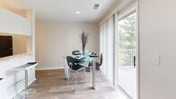 Located in Indianapolis, IN (46250), this single-floor residence offers a thoughtfully designed layout that maximizes comfort and functionality. The combined kitchen and dining area serves as the heart of the home, featuring granite countertops, white cabinetry with brushed nickel hardware, and black appliances. Wood-look flooring runs throughout this space, which opens to a private outdoor balcony through a large sliding glass door, flooding the area with natural light and offering pleasant views of the surrounding greenery. The spacious primary bedroom is carpeted for warmth and comfort, with a window that allows in natural light, and connects directly to a dedicated closet, providing generous storage. The bathroom is clean and well-finished, showcasing granite countertops, white cabinetry, wood-look flooring, and a shower-tub combination. Two hallways connect the rooms efficiently, contributing to a smooth and logical flow throughout the residence. Neutral tones on the walls and classic finishes throughout create a bright, clean ambiance that is both welcoming and versatile. The overall design balances practical living with comfortable, modern touches in a well-organized single-level floor plan.
