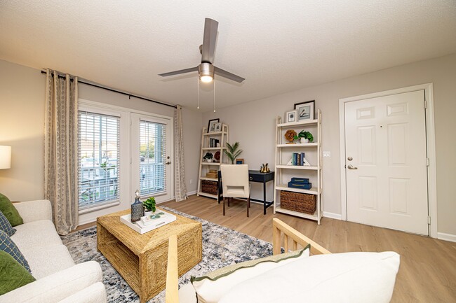 Spacious living room with hardwood-style flooring - The Collins Apartment Homes