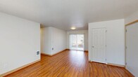 Located at 133 N 29th Ave in Cornelius, Oregon, this single-floor home offers a functional and well-organized layout with two bedrooms, two bathrooms, and a thoughtfully arranged living space. The interior features warm wood-look laminate flooring throughout the main living areas, complemented by neutral white walls and textured ceilings that give the home a clean, bright feel.

The spacious living room receives generous natural light through a sliding glass door fitted with vertical blinds, opening to the outdoors. A central hallway connects the main living areas to the private bedrooms, with wall-mounted heating vents ensuring comfort throughout. Both bedrooms are carpeted and feature windows with vertical blinds that allow natural light to filter in, creating a calm and restful atmosphere. The primary bedroom offers a comfortable footprint with dedicated closet space.

The kitchen and dining area are combined into one practical space, outfitted with warm-toned oak cabinetry, a stainless steel range, a dishwasher, and a white refrigerator. Both bathrooms are bright and functional, with windows providing natural ventilation. A dedicated laundry room includes washer and dryer hookups with wire shelving above. Three closets throughout the home provide ample storage, rounding out this practical and comfortable residence.