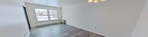 This 900 square foot apartment in Latham, NY offers a well-designed living space with two bedrooms and one bathroom. The unit features a modern kitchen equipped with wooden cabinetry, black appliances, and ample counter space. The living area is bright and airy, with large windows that allow natural light to flood the space. Gray wood-look flooring runs throughout the main living areas, creating a contemporary aesthetic.

The primary bedroom, measuring 200 square feet, provides a generous space for rest and relaxation. Both bedrooms feature neutral carpeting and clean, white walls. The bathroom is efficiently designed with a single vanity, toilet, and shower/tub combination.

A notable feature of this apartment is the outdoor balcony, accessible through sliding glass doors, offering a private outdoor space. The unit also includes baseboard heating for comfort during colder months.

The apartment's layout incorporates a hallway and closet space, enhancing the overall functionality of the home. With its neutral color palette and modern finishes, this apartment presents a blank canvas for personal styling while providing all the essentials for comfortable suburban living.