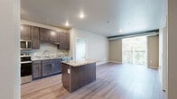 Located at 412 3rd St E in Hastings, MN, this 1-bedroom, 1-bathroom residence offers a thoughtfully designed open-concept layout that maximizes every square foot. The combined kitchen and living area serves as the heart of the home, where rich dark cabinetry, striking granite countertops, and a full suite of stainless steel appliances—including a dishwasher, microwave, and refrigerator—create a functional and stylish kitchen. A granite-topped island with bar seating adds casual dining space and anchors the layout. Light wood-tone flooring runs throughout, complementing the neutral palette. The living area is bright and inviting, benefiting from a sliding glass door that opens to a private balcony with outdoor views, allowing natural light to fill the space. The bedroom is a comfortable retreat, featuring plush carpeting, large windows overlooking the surrounding area, and exposed ductwork that adds an industrial character. A dedicated closet with wire shelving provides practical storage. The bathroom echoes the home's refined finishes with a granite vanity countertop, dark cabinetry with brushed hardware, and a framed mirror. The entryway offers a clean transition into the living space, completing this efficiently designed and attractively finished residence.