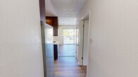 Located at 2710 Spyglass Drive in the coastal community of Pismo Beach, California, this one-bedroom, one-bathroom unit offers a well-organized and efficiently designed single-floor layout. The living areas feature warm wood-look hardwood flooring that flows throughout, complemented by neutral white walls and textured ceilings that lend a classic character to the space.

The kitchen is a functional highlight, showcasing rich, dark wood cabinetry extending floor to ceiling for ample storage. It is equipped with a stainless steel refrigerator, an electric range with a stainless steel oven, a built-in cooktop set into the light stone-toned countertop, and a single-basin sink. The kitchen connects openly to the rest of the unit, making it practical for everyday use.

The bedroom is a comfortable, well-proportioned room bathed in natural light from a sliding window that frames views of the surrounding greenery. Clean white walls and consistent hardwood flooring create a calm and airy atmosphere.

The bathroom features a light stone countertop with a single sink vanity, a large wall mirror, and a combination tub and shower, along with additional cabinet storage for convenience.

A private balcony off the unit provides outdoor space with open views of the surrounding neighborhood and the clear California sky, adding to the relaxed coastal lifestyle this Pismo Beach location affords.